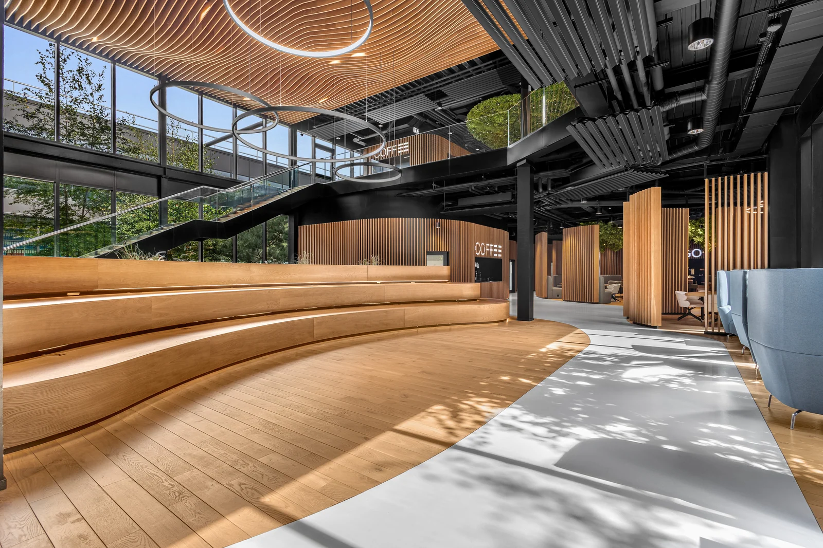 La longue banquette en bois suit une courbe face aux grandes fenêtres.
