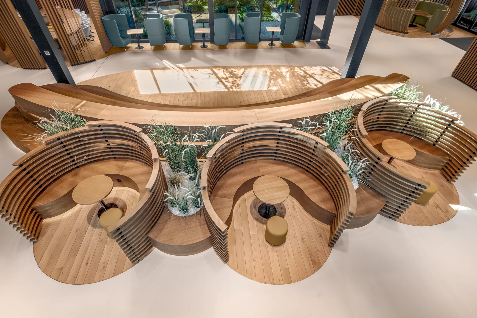 Vue plongeante sur trois alcôves circulaires, leurs jardinières et la banquette courbe.