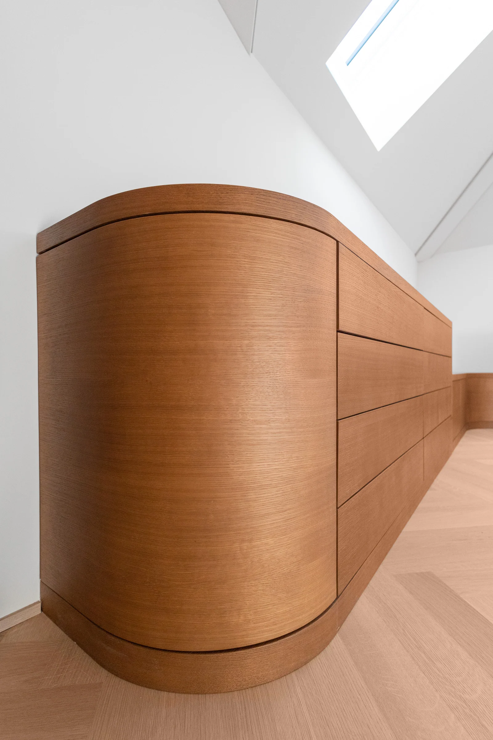 Détail de l’extrémité arrondie d’une commode à tiroirs.