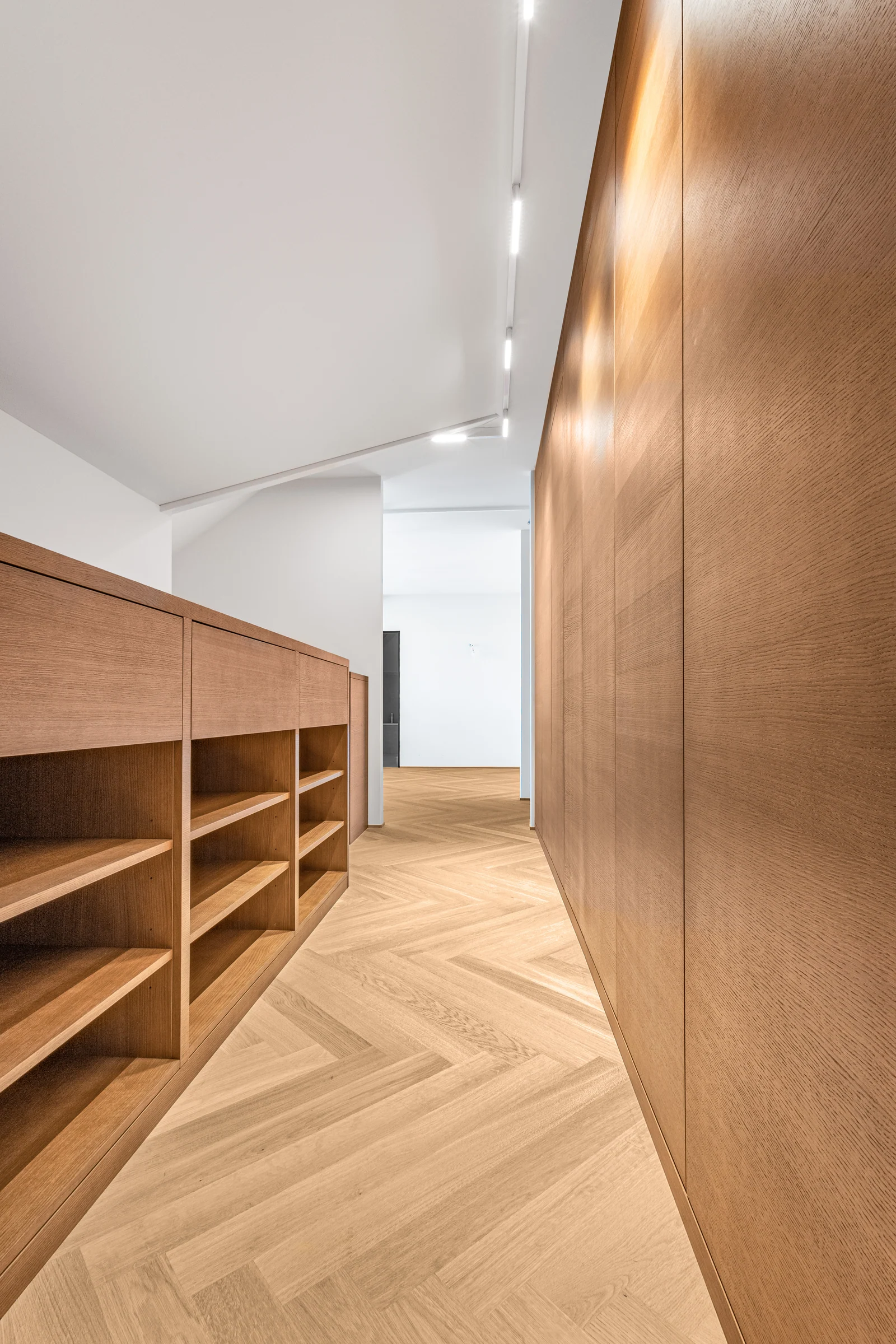 Le passage longe les façades en bois et le volume des bibliothèques.