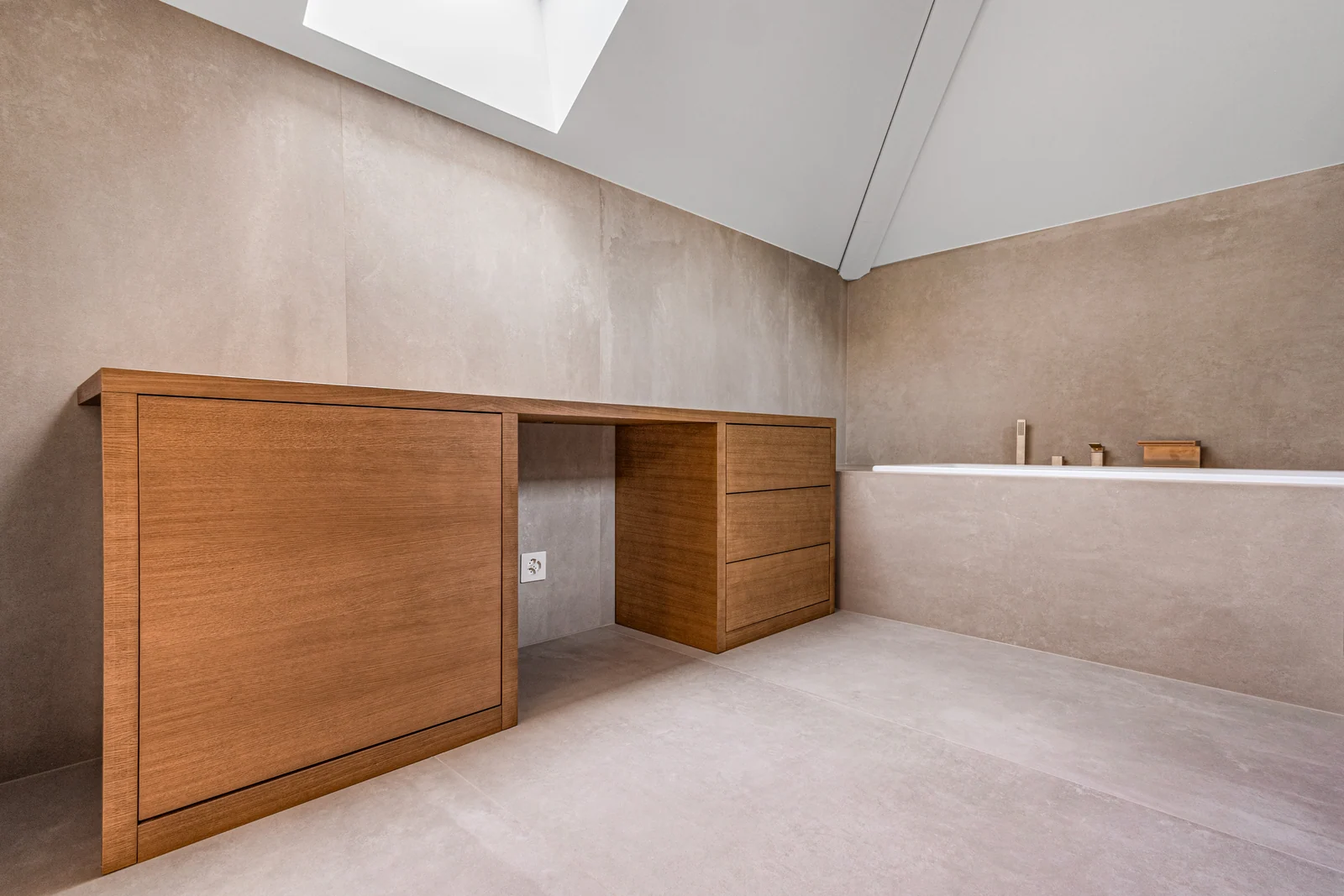 Le mobilier de la salle de bains s’intègre sous la fenêtre de toit.