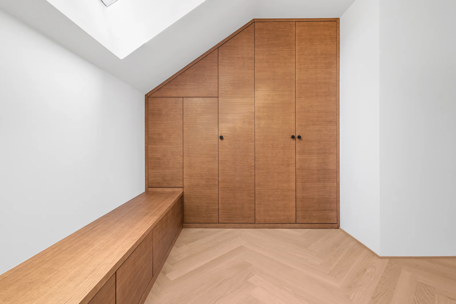 Les portes suivent la pente de la toiture, dans le prolongement de la banquette.